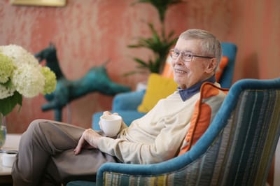 Senior resident enjoying a moment in a cozy lounge area