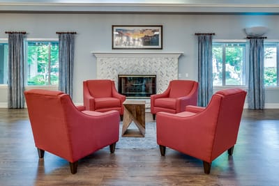 Cozy common area with red armchairs and a fireplace