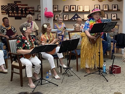 Residents performing music with ukuleles in a common area