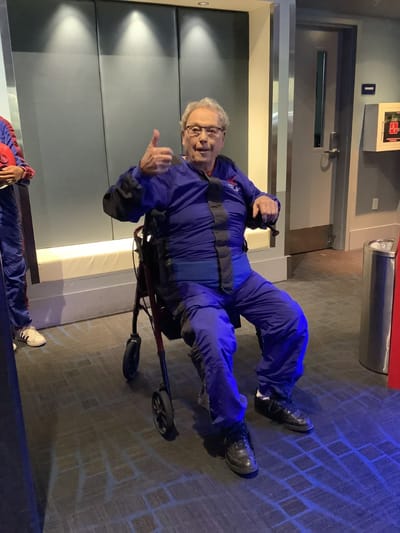 Senior resident giving a thumbs up in a vibrant setting.