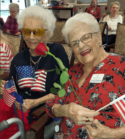Residents enjoying an activity with flags and flowers