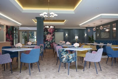 Bright dining area with colorful chairs and floral decor