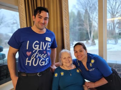 Staff members and a resident smiling in a common area