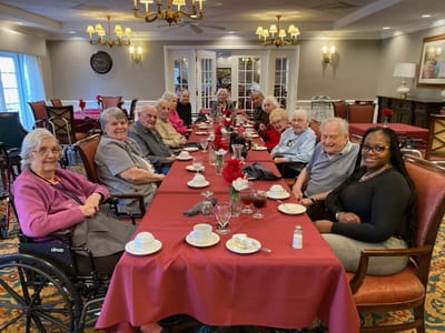 Residents and staff enjoying a meal together in the dining room