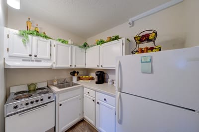 Bright kitchen area with white cabinets and appliances