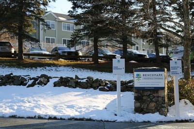 Facility exterior with main entrance sign and parking area