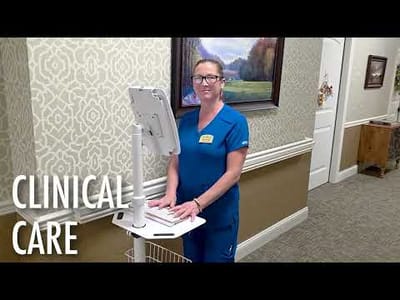 Staff member assisting with clinical care in a facility hallway