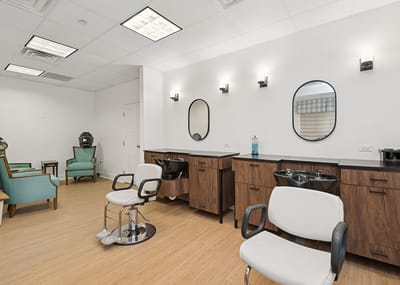 Hair salon area with styling chairs and wash stations