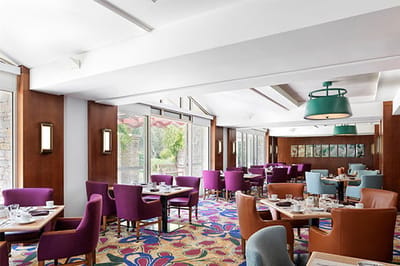 Bright dining area with colorful seating and floral decor