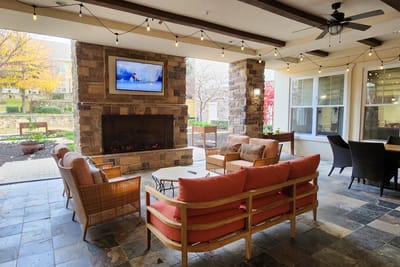 Cozy outdoor lounge area with seating and fireplace