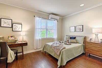 A well-decorated resident room with a bed and study area