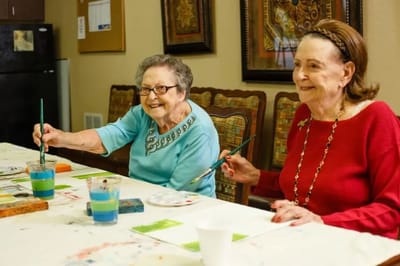 Two residents enjoying a painting activity