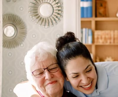 A caregiver and resident sharing a joyful moment