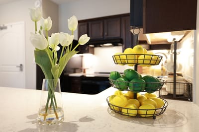 A beautifully arranged kitchen with fruits and flowers