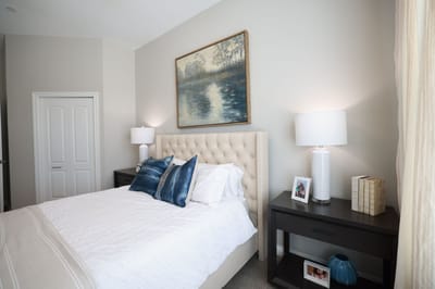 A well-furnished interior bedroom with a bed and lamps