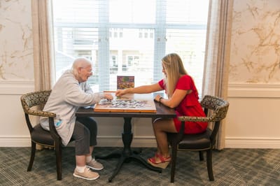 Resident and staff member enjoying puzzle activity together