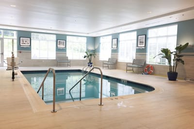 Indoor swimming pool area with seating and plants