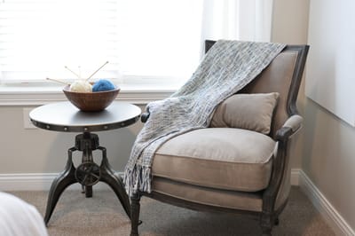 Cozy chair with a throw and a bowl of yarn