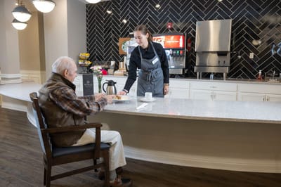 A staff member serving a resident at a counter