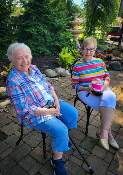 Two senior women enjoying time outdoors in a garden