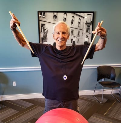 Resident engaging in an activity with drumsticks