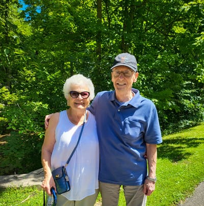 Two seniors smiling together in an outdoor setting