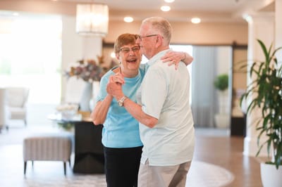 Couple dancing joyfully in a bright common area