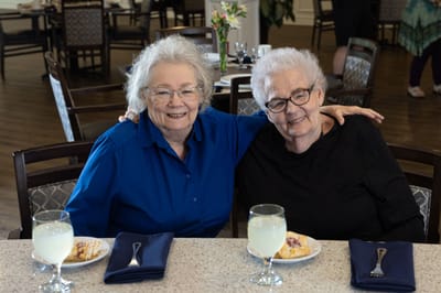 Two residents enjoying dessert at a dining table