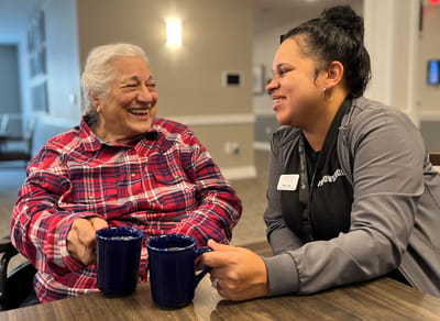 A resident and staff member sharing a joyful moment