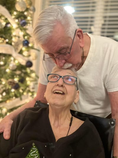 A senior woman smiling at her companion in a cozy setting