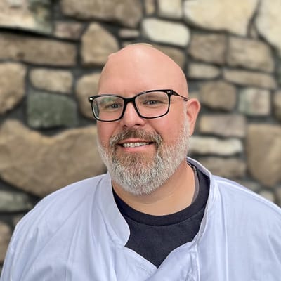 Chef smiling in front of a stone wall
