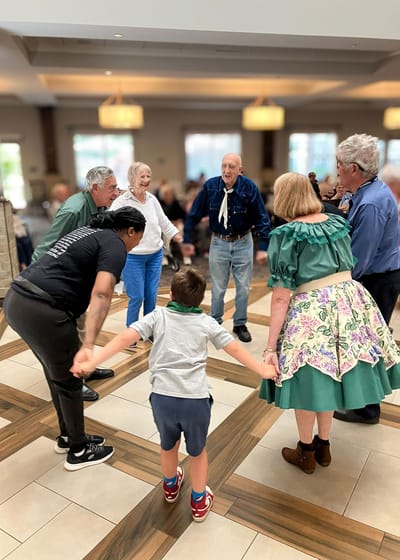 Residents and staff dancing in a communal area