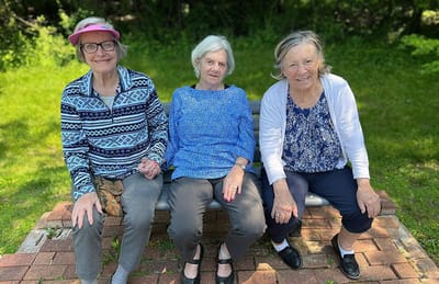 Three women sitting together in a garden