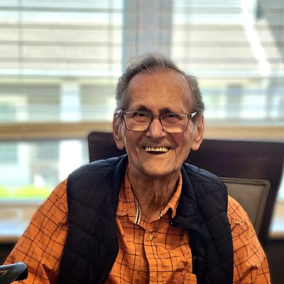An elderly man smiling in a common area