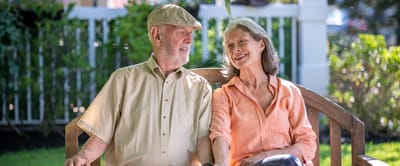 A senior couple enjoying time outdoors on a bench