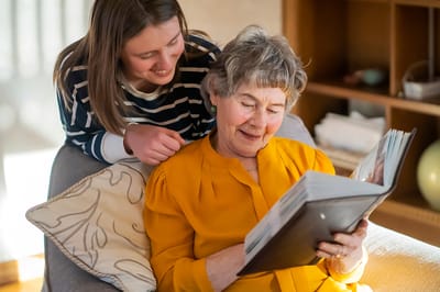 A caregiver reading with a resident in a cozy setting