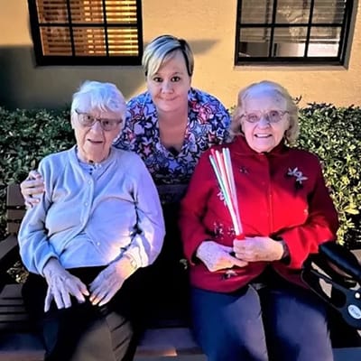 Residents enjoying time with staff in a garden