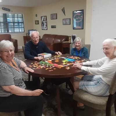 Residents enjoying a puzzle activity in the common area