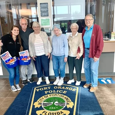 Residents and staff posing in a facility common area
