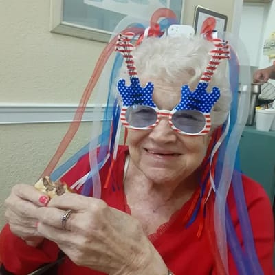 Resident enjoying a festive snack with themed glasses