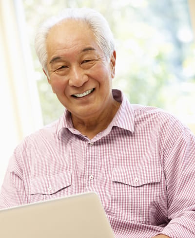 Smiling senior man using a laptop