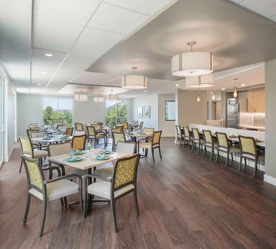Bright dining room with tables and chairs set up