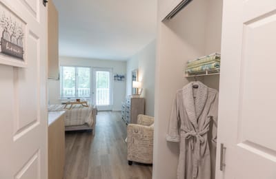 Bright interior of a resident room with a bed and chair