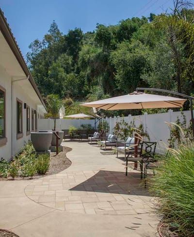 Outdoor patio area with seating and greenery
