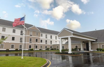 Exterior view of Mira Vie at Toms River with garden and flag