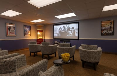 A cozy movie room with theater seating and popcorn