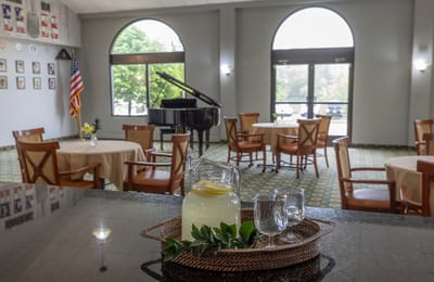 Interior view of a social area with a piano and refreshments