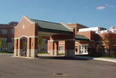 Entrance of a senior living facility with a covered entrance.