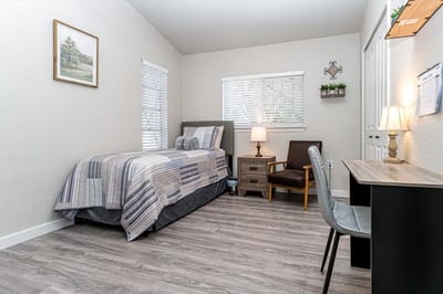 Private resident room with bed and chair