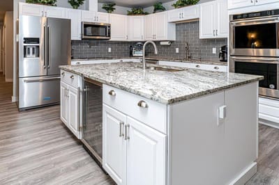 Modern kitchen interior with white cabinetry and granite island